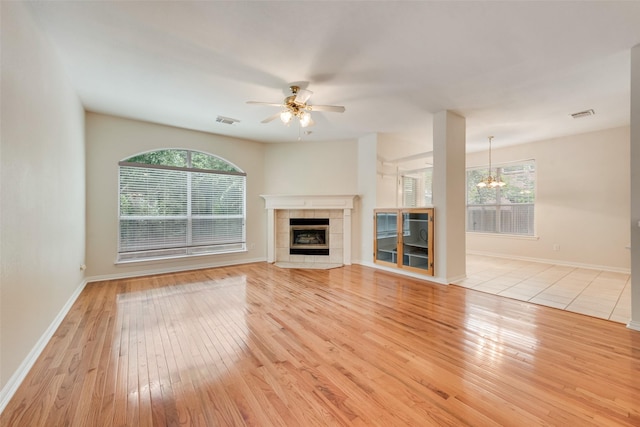 3232 Kent Dr, Flower Mound, TX 75022 - unfurnished living room featuring light wood-style flooring, healthy amount of natural light, a ceiling fan, and a chandelier