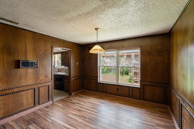 110 S Capri Dr, Duncanville, TX 75116 - unfurnished dining area with a textured ceiling, wood finished floors, and wood walls