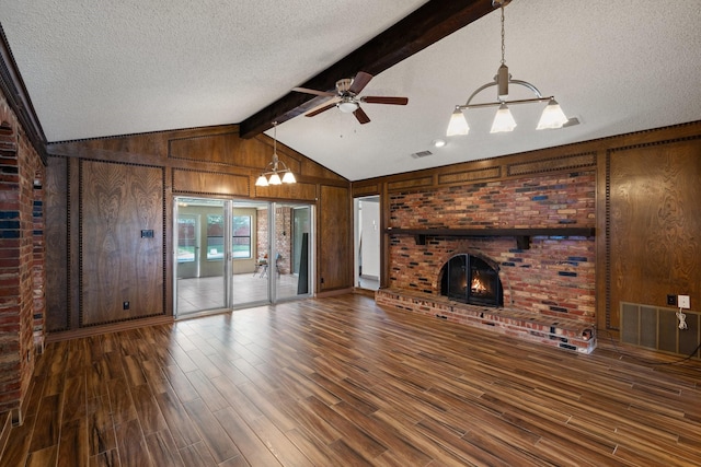 110 S Capri Dr, Duncanville, TX 75116 - unfurnished living room with a chandelier, wooden walls, wood finished floors, a textured ceiling, and a brick fireplace