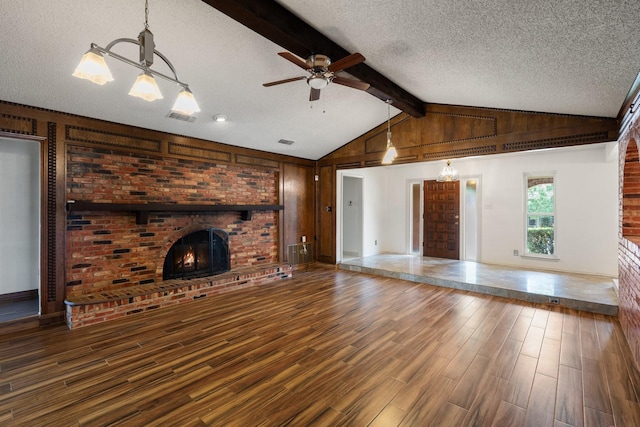 110 S Capri Dr, Duncanville, TX 75116 - unfurnished living room featuring wood finished floors, a brick fireplace, a textured ceiling, a ceiling fan, and a chandelier