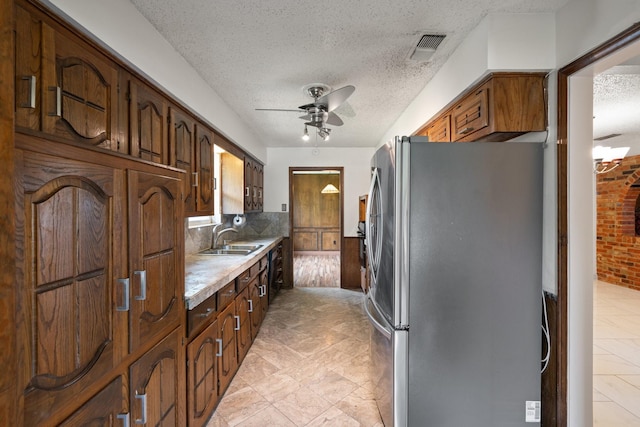 110 S Capri Dr, Duncanville, TX 75116 - kitchen with freestanding refrigerator, ceiling fan, light countertops, a textured ceiling, and tasteful backsplash