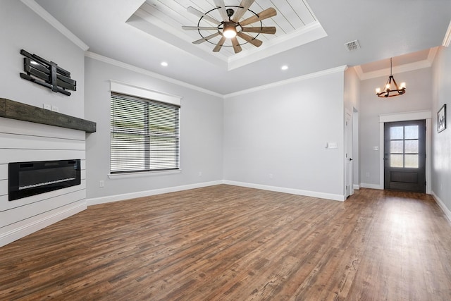 207 Morning Mist Trl, Abilene, TX 79602 - unfurnished living room featuring a tray ceiling, a glass covered fireplace, a chandelier, wood finished floors, and recessed lighting