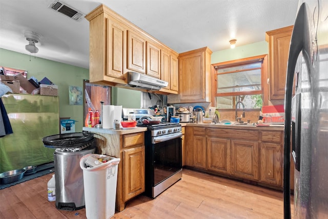 303 E Broadway St, Prosper, TX 75078 - kitchen featuring refrigerator with ice dispenser, stainless steel stove, a sink, and light wood finished floors