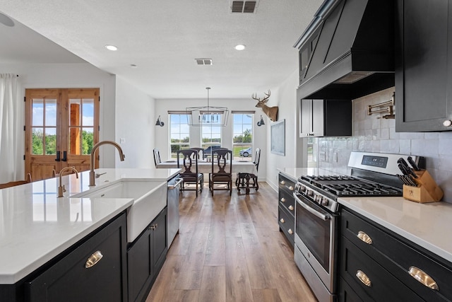 7954 Lax Dr, Fort Worth, TX 76126 - kitchen featuring stainless steel appliances, dark cabinets, a sink, light wood finished floors, and recessed lighting