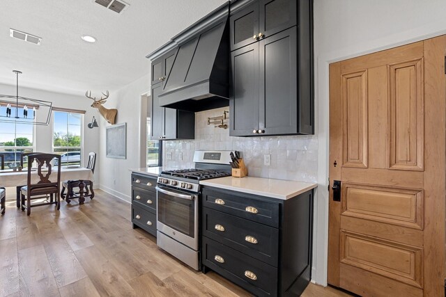7954 Lax Dr, Fort Worth, TX 76126 - kitchen featuring stainless steel gas stove, backsplash, light countertops, dark cabinets, and light wood-style floors