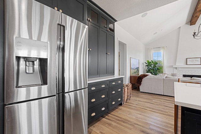 7954 Lax Dr, Fort Worth, TX 76126 - kitchen featuring stainless steel fridge, lofted ceiling, light wood-type flooring, light countertops, and dark cabinetry