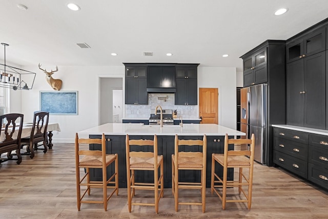 7954 Lax Dr, Fort Worth, TX 76126 - kitchen featuring stainless steel appliances, custom range hood, dark cabinets, light countertops, and recessed lighting
