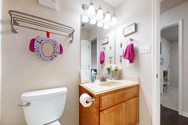 337 Grace Cir, Hurst, TX 76053 - half bathroom featuring vanity, toilet, and wood finished floors