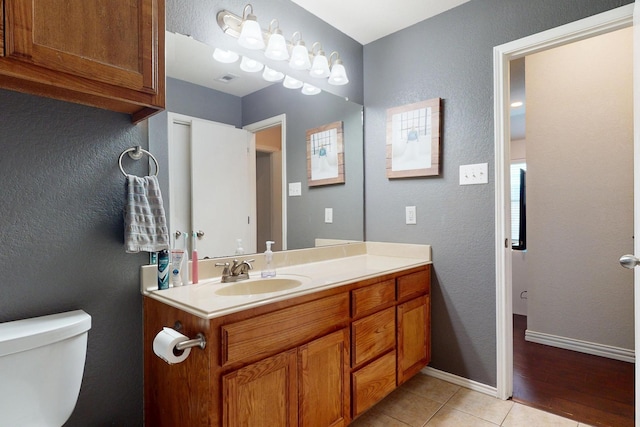 337 Grace Cir, Hurst, TX 76053 - bathroom with vanity, toilet, baseboards, a textured wall, and tile patterned flooring