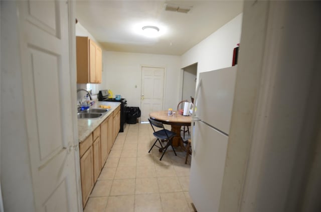4413 Merida Ave, Fort Worth, TX 76115 - kitchen with a sink, freestanding refrigerator, black / electric stove, light countertops, and light tile patterned floors