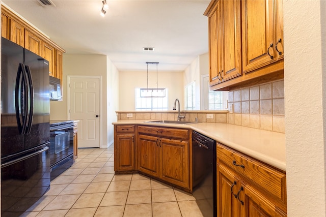 258 Pecan Hollow Cir, Anna, TX 75409 - kitchen with black appliances, brown cabinetry, light tile patterned floors, light countertops, and a peninsula