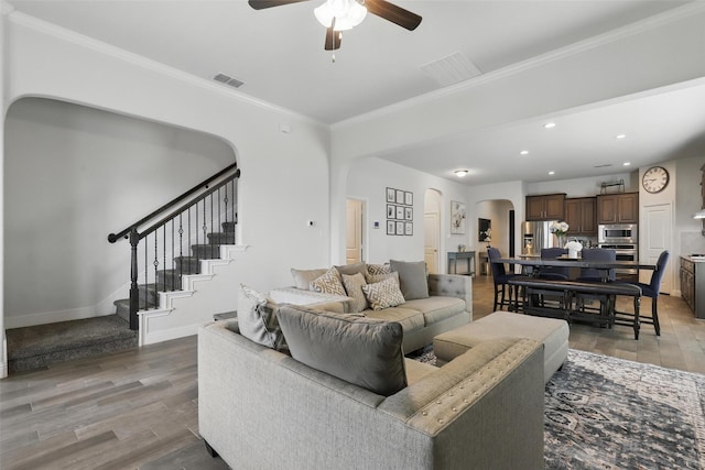 14825 Complacent Way, Aledo, TX 76008 - living room with arched walkways, ceiling fan, light wood-style floors, crown molding, and stairway