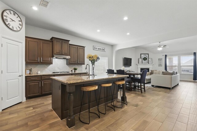 14825 Complacent Way, Aledo, TX 76008 - kitchen with a sink, ceiling fan, light wood finished floors, under cabinet range hood, and a breakfast bar