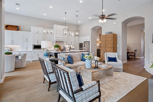 3228 Zenyatta Ct, Celina, TX 75009 - living area featuring arched walkways, a ceiling fan, light wood finished floors, recessed lighting, and baseboards