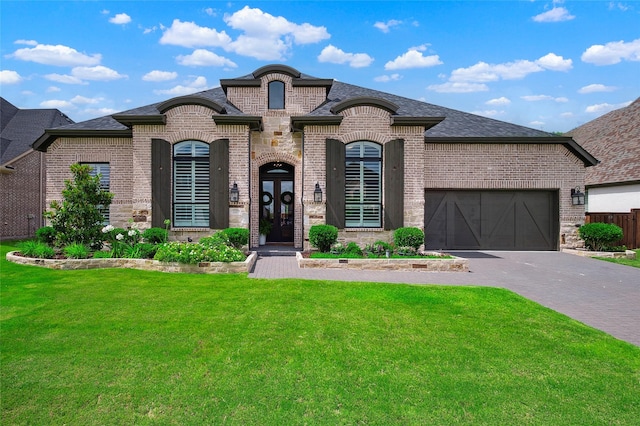 3228 Zenyatta Ct, Celina, TX 75009 - french country inspired facade featuring brick siding, a front lawn, a garage, driveway, and a shingled roof