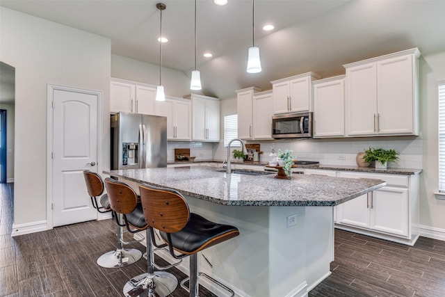 1814 Indigo Creek Ln, Wylie, TX 75098 - kitchen featuring stainless steel appliances, white cabinets, dark wood-style flooring, a breakfast bar, and backsplash