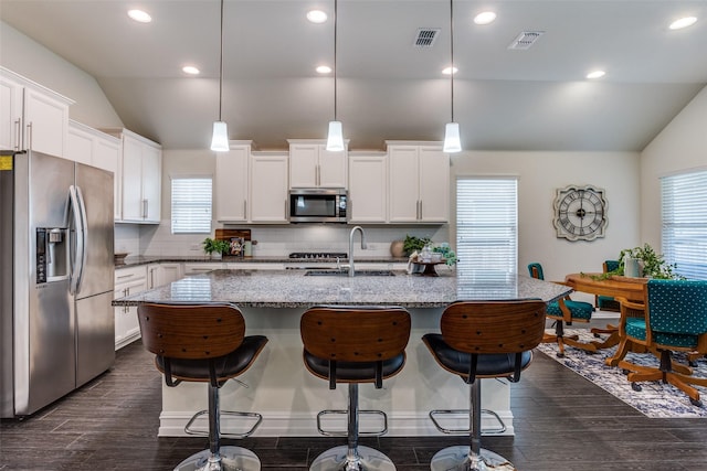 1814 Indigo Creek Ln, Wylie, TX 75098 - kitchen featuring stainless steel appliances, vaulted ceiling, a sink, dark wood-style flooring, and light stone countertops
