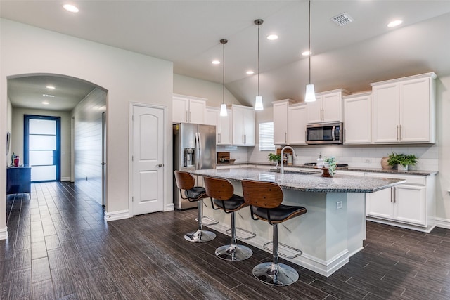 1814 Indigo Creek Ln, Wylie, TX 75098 - kitchen featuring appliances with stainless steel finishes, a sink, arched walkways, healthy amount of natural light, and vaulted ceiling