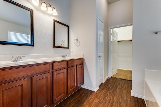 3820 Denridge Ln, Fort Worth, TX 76262 - bathroom with double vanity, wood finished floors, a bath, baseboards, and a closet