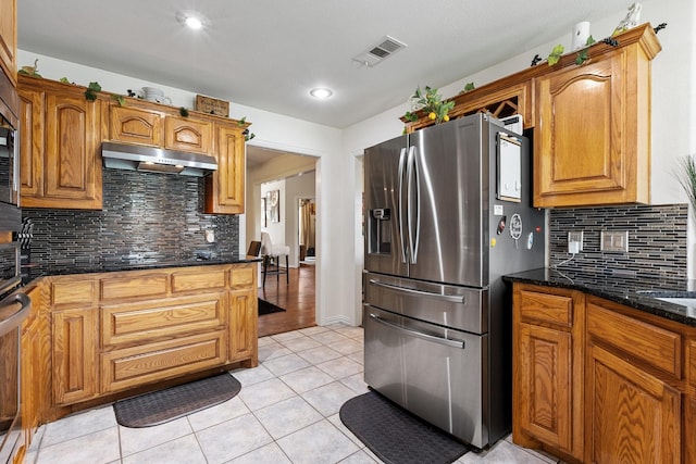 300 Burtonwood Cir, Ovilla, TX 75154 - kitchen with stainless steel refrigerator with ice dispenser, under cabinet range hood, tasteful backsplash, dark stone countertops, and light tile patterned floors
