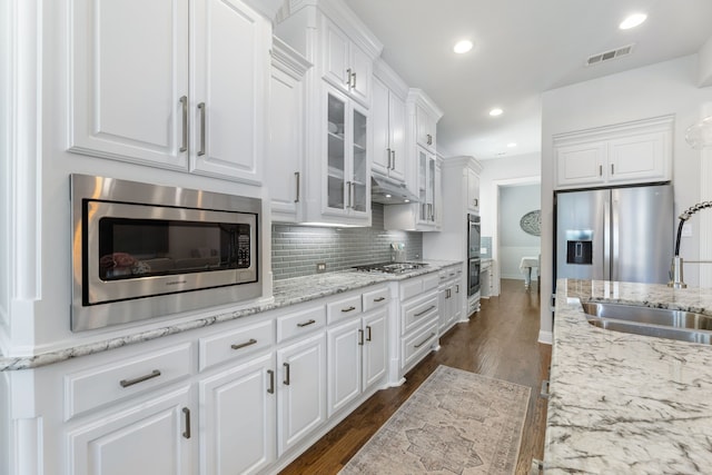3025 Speyburn, The Colony, TX 75056 - kitchen featuring appliances with stainless steel finishes, a sink, white cabinets, backsplash, and recessed lighting