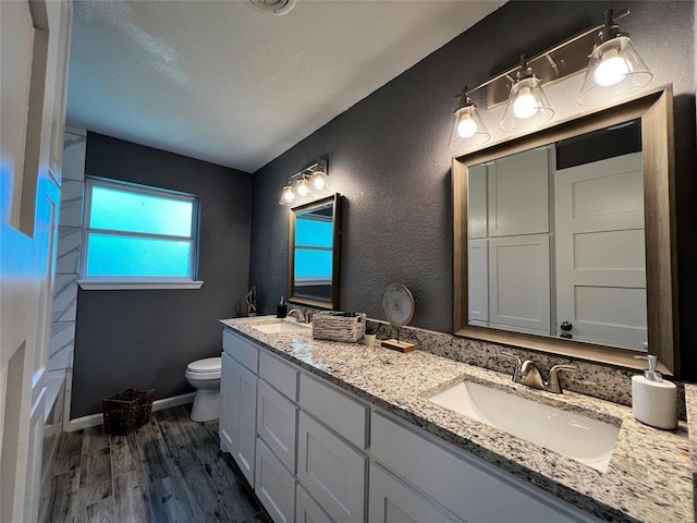 1432 Hurstview Dr, Hurst, TX 76053 - full bathroom with double vanity, wood finished floors, toilet, and baseboards