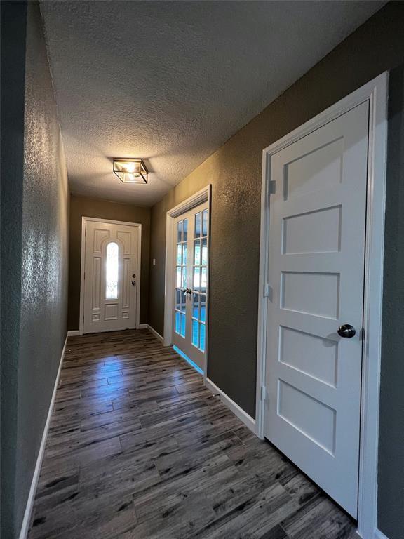 1432 Hurstview Dr, Hurst, TX 76053 - foyer with french doors, a textured wall, a textured ceiling, wood finished floors, and baseboards