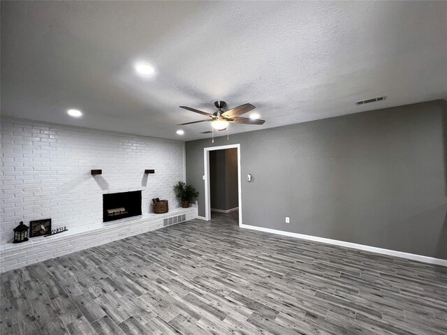1432 Hurstview Dr, Hurst, TX 76053 - unfurnished living room featuring wood finished floors, a ceiling fan, baseboards, a brick fireplace, and recessed lighting