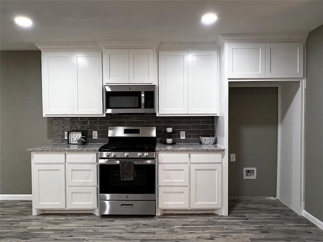 1432 Hurstview Dr, Hurst, TX 76053 - kitchen with stainless steel appliances, white cabinets, backsplash, light wood-type flooring, and recessed lighting