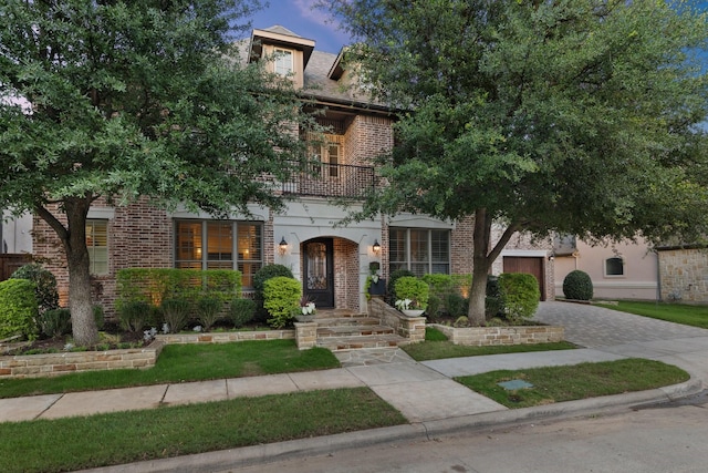 6208 Jacqueline Dr, Plano, TX 75024 - view of front of house with a balcony, driveway, brick siding, and a garage
