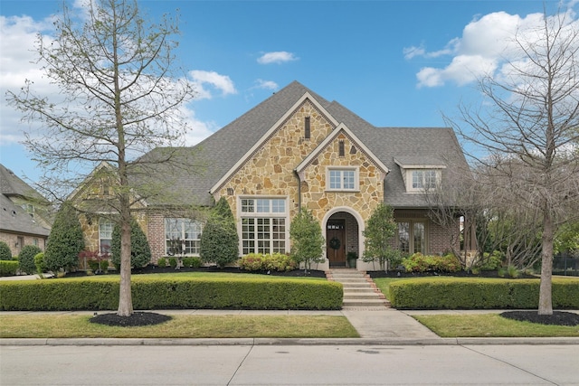 12669 Winding Hollow Ln, Frisco, TX 75033 - view of front of home with stone siding, a front yard, and a shingled roof
