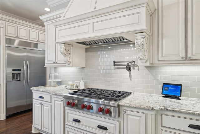 12669 Winding Hollow Ln, Frisco, TX 75033 - kitchen with appliances with stainless steel finishes, decorative backsplash, light stone counters, and ornamental molding