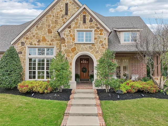 12669 Winding Hollow Ln, Frisco, TX 75033 - view of front of home featuring stone siding, a front lawn, and roof with shingles