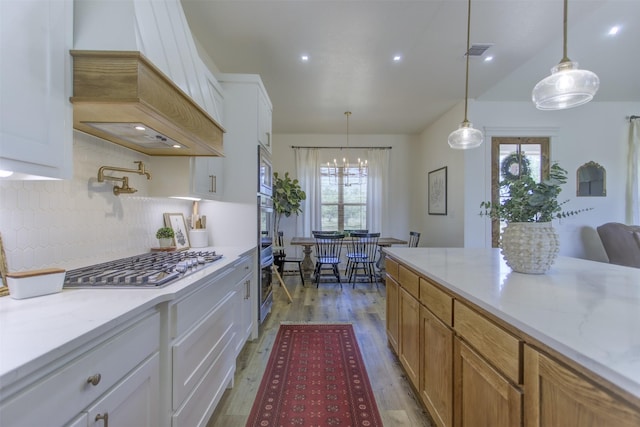 550 Capstone Ridge Dr, Santo, TX 76472 - kitchen featuring stainless steel gas cooktop, custom exhaust hood, light wood-type flooring, backsplash, and white cabinets