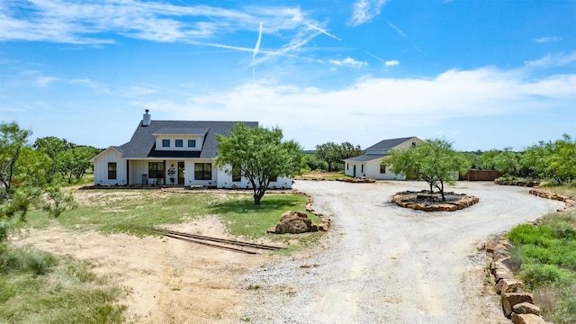 550 Capstone Ridge Dr, Santo, TX 76472 - view of front of home featuring curved driveway, covered porch, and a chimney
