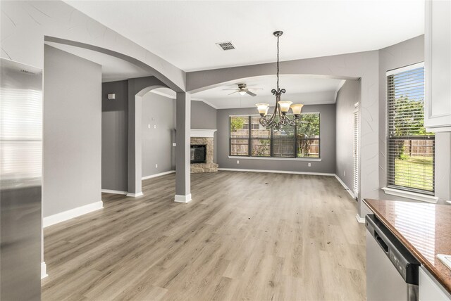 7500 Archer Way, Mckinney, TX 75072 - unfurnished living room with a chandelier, light wood-style flooring, a fireplace, baseboards, and plenty of natural light
