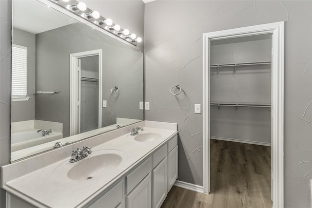 7500 Archer Way, Mckinney, TX 75072 - bathroom with double vanity, wood finished floors, a spacious closet, and a bath