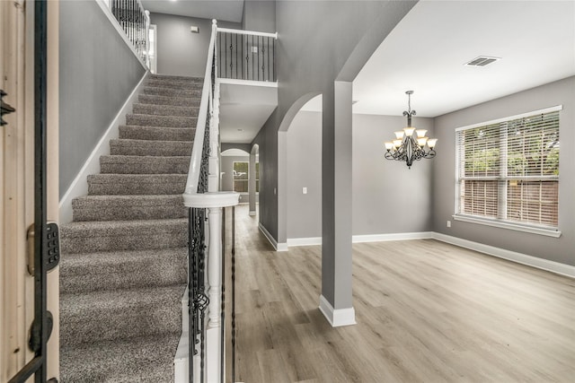 7500 Archer Way, Mckinney, TX 75072 - stairway featuring arched walkways, wood finished floors, baseboards, and a chandelier