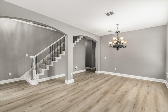 7500 Archer Way, Mckinney, TX 75072 - unfurnished living room with light wood finished floors, arched walkways, baseboards, and stairs