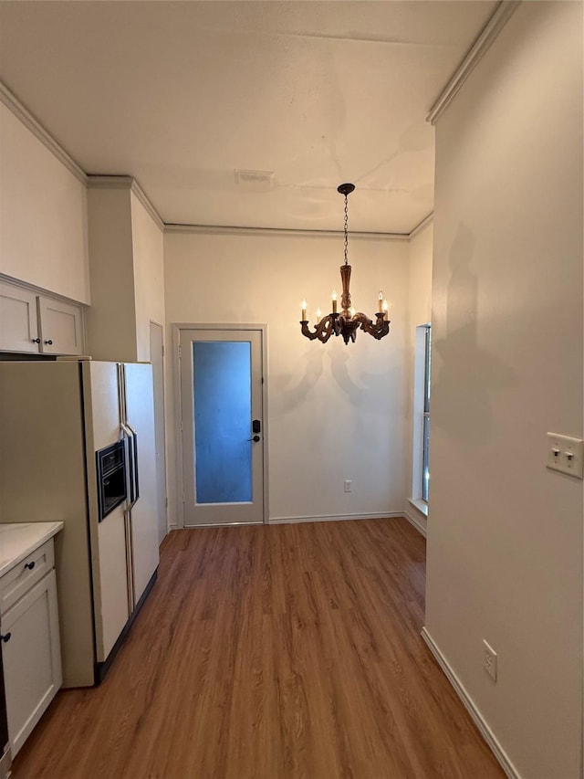 10416 High Hollows Dr Unit 232, Dallas, TX 75230 - unfurnished dining area with a chandelier, wood finished floors, baseboards, and crown molding