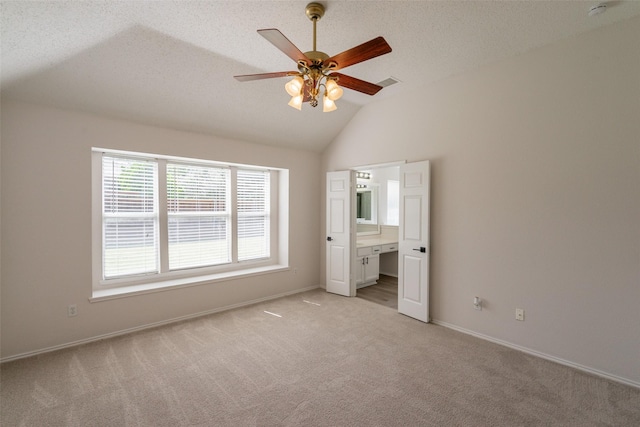 6909 Highland Crest Ln, Sachse, TX 75048 - unfurnished bedroom with light colored carpet, vaulted ceiling, baseboards, ensuite bath, and a textured ceiling