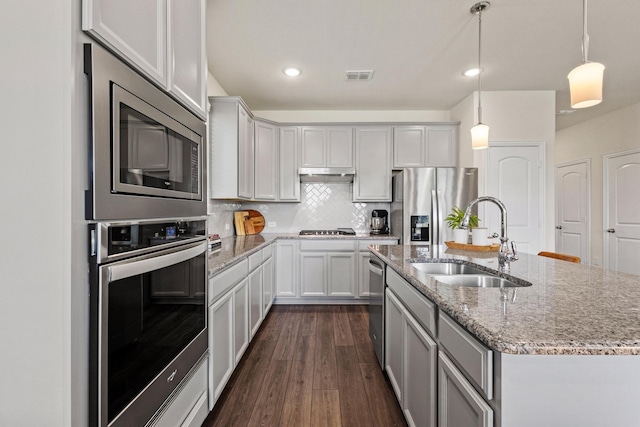 1021 Adelyn St, Anna, TX 75409 - kitchen with appliances with stainless steel finishes, a sink, a kitchen island with sink, dark wood finished floors, and backsplash