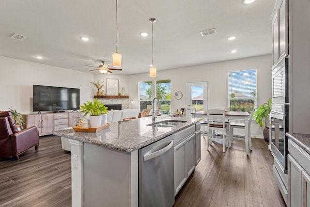 1021 Adelyn St, Anna, TX 75409 - kitchen with stainless steel appliances, a sink, a fireplace, dark wood-type flooring, and recessed lighting
