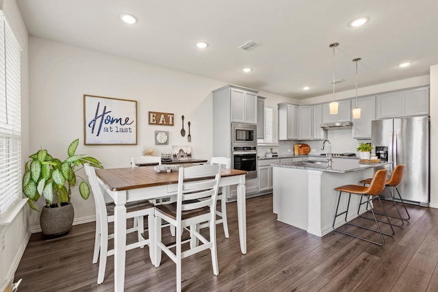 1021 Adelyn St, Anna, TX 75409 - kitchen featuring stainless steel appliances, dark wood-style flooring, recessed lighting, an island with sink, and light stone counters