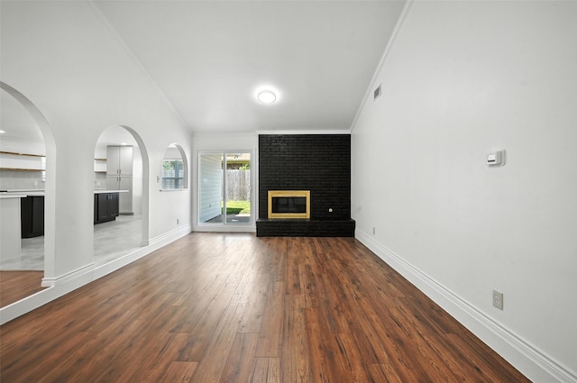 2005 Stacey Ct, Arlington, TX 76013 - unfurnished living room with a fireplace, wood finished floors, ornamental molding, and vaulted ceiling