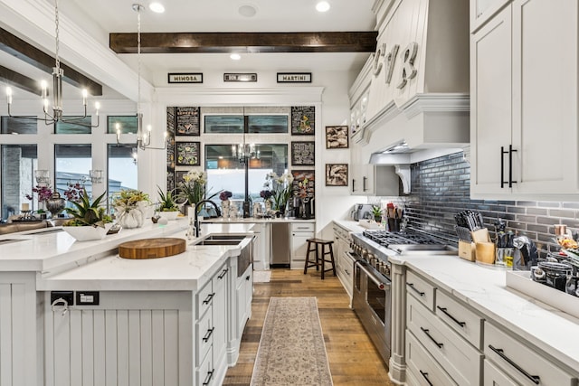 1001 Colina Vista Ln, Crowley, TX 76036 - kitchen featuring a chandelier, high end stainless steel range, beamed ceiling, light wood-type flooring, and an island with sink