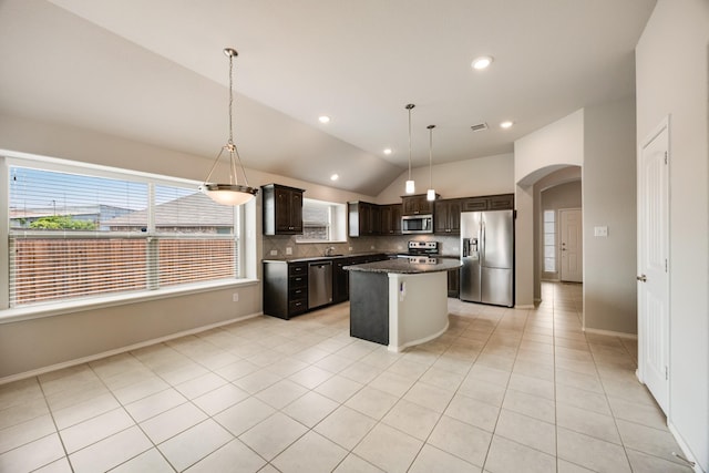 2133 Blakely Ct, Fort Worth, TX 76134 - kitchen featuring stainless steel appliances, arched walkways, dark brown cabinetry, a kitchen island, and lofted ceiling