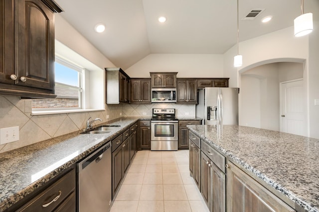 2133 Blakely Ct, Fort Worth, TX 76134 - kitchen with appliances with stainless steel finishes, dark brown cabinets, a sink, tasteful backsplash, and stone countertops