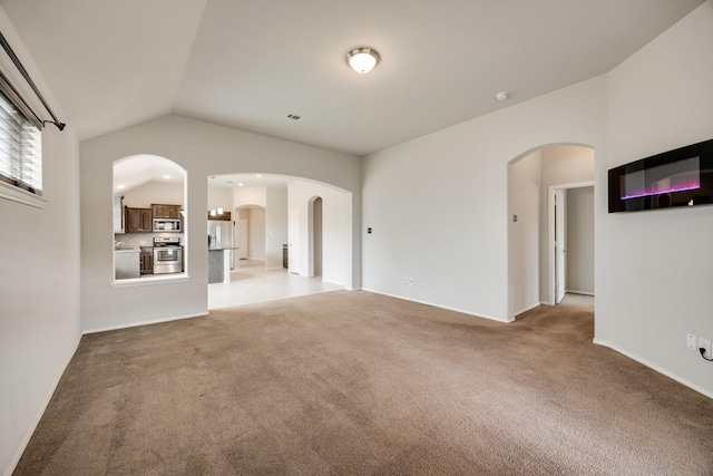 2133 Blakely Ct, Fort Worth, TX 76134 - unfurnished living room featuring light colored carpet, lofted ceiling, and arched walkways