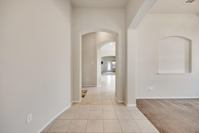 2133 Blakely Ct, Fort Worth, TX 76134 - hallway featuring light tile patterned floors, arched walkways, and baseboards